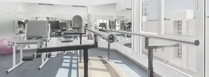 A rehabilitation centre with parallel bars and exercise equipment