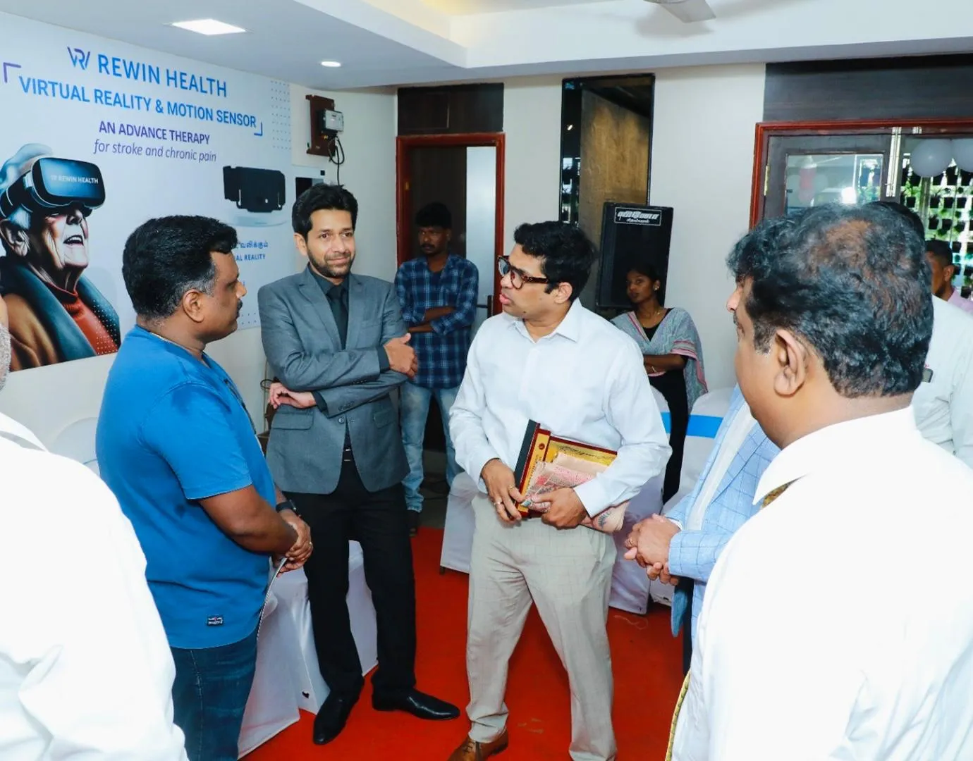 Clinicians discussing Rewin’s VR and motion-sensor therapy at a Rewin Health event